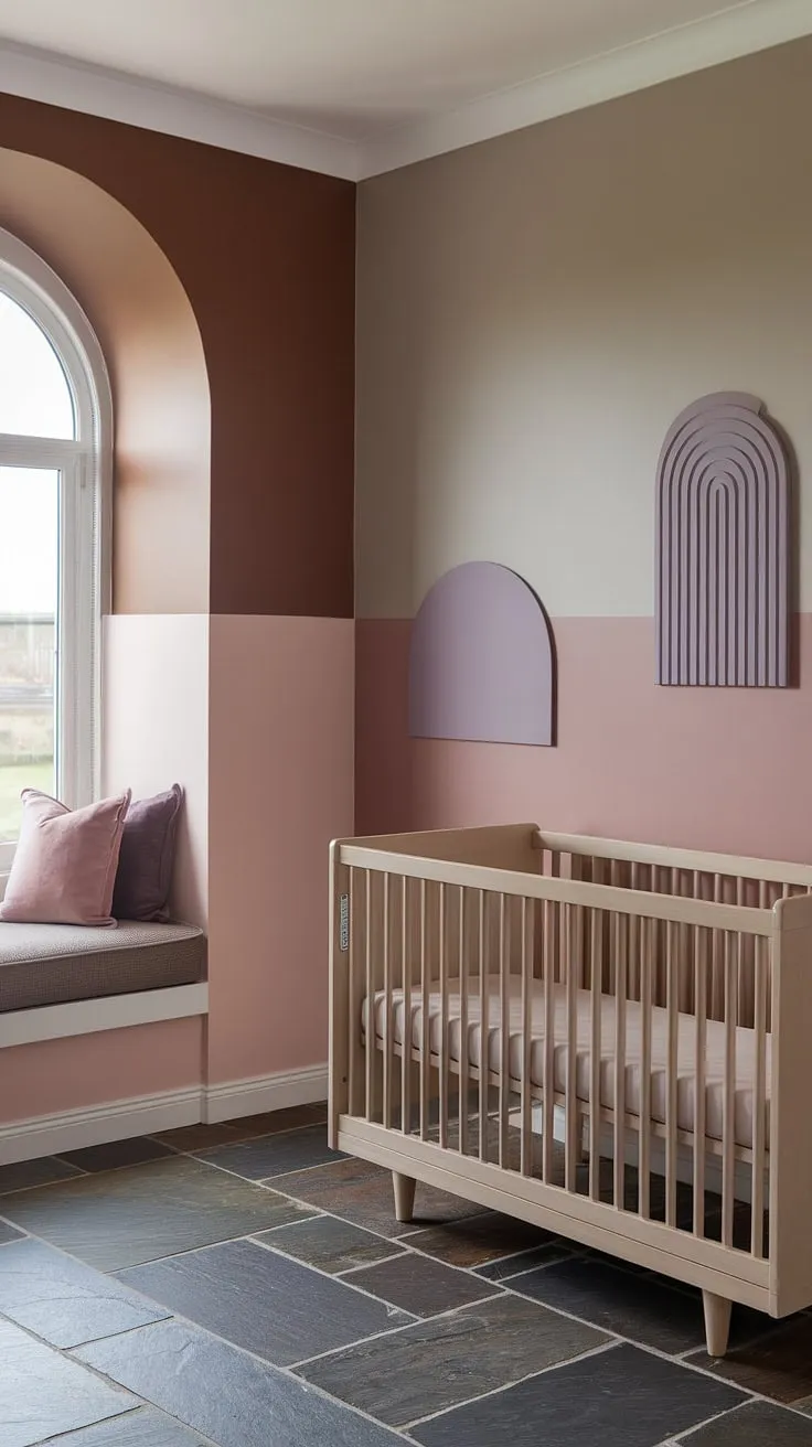 This taupe and pink nursery, featuring a stunning light brown accent wall nursery and a grey and mauve nursery wall, is the epitome of gentle sophistication.  The crib on window wall maximizes natural light, while the neutral purple nursery decor adds a touch of whimsy.  The Sashay Sand Sherwin Williams nursery paint and cinnamon slate nursery flooring complete this serene and stylish space.