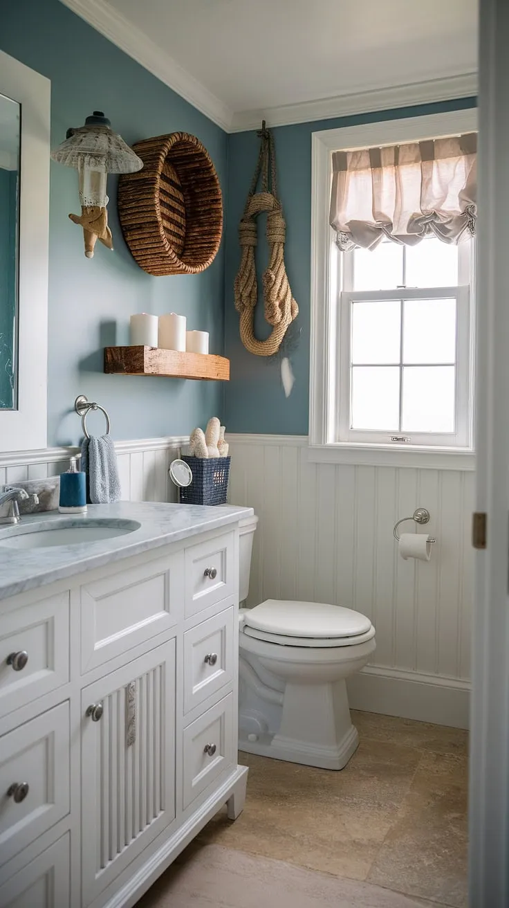 Transform your guest bathroom into a coastal oasis with this stunning bathroom remodel.  This chic coastal bathroom boasts a calming blue hue and thoughtful coastal bathroom ideas, making it the ideal beach guest bathroom.  From the nautical decor to the marble vanity, every detail contributes to the perfect beach home bathroom ideas, showcasing a half bath coastal decor that's both stylish and functional.  Find inspiration for your own bathroom decor coastal style.