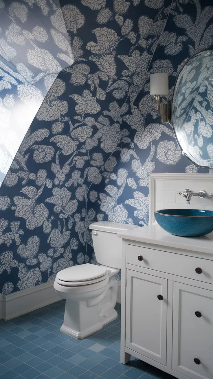 Coastal charm meets preppy sophistication in this powder room.  The light blue bathroom wallpaper, reminiscent of a Serena and Lily design, perfectly complements the blue tile and slanted ceiling, creating a serene and stylish half bath.