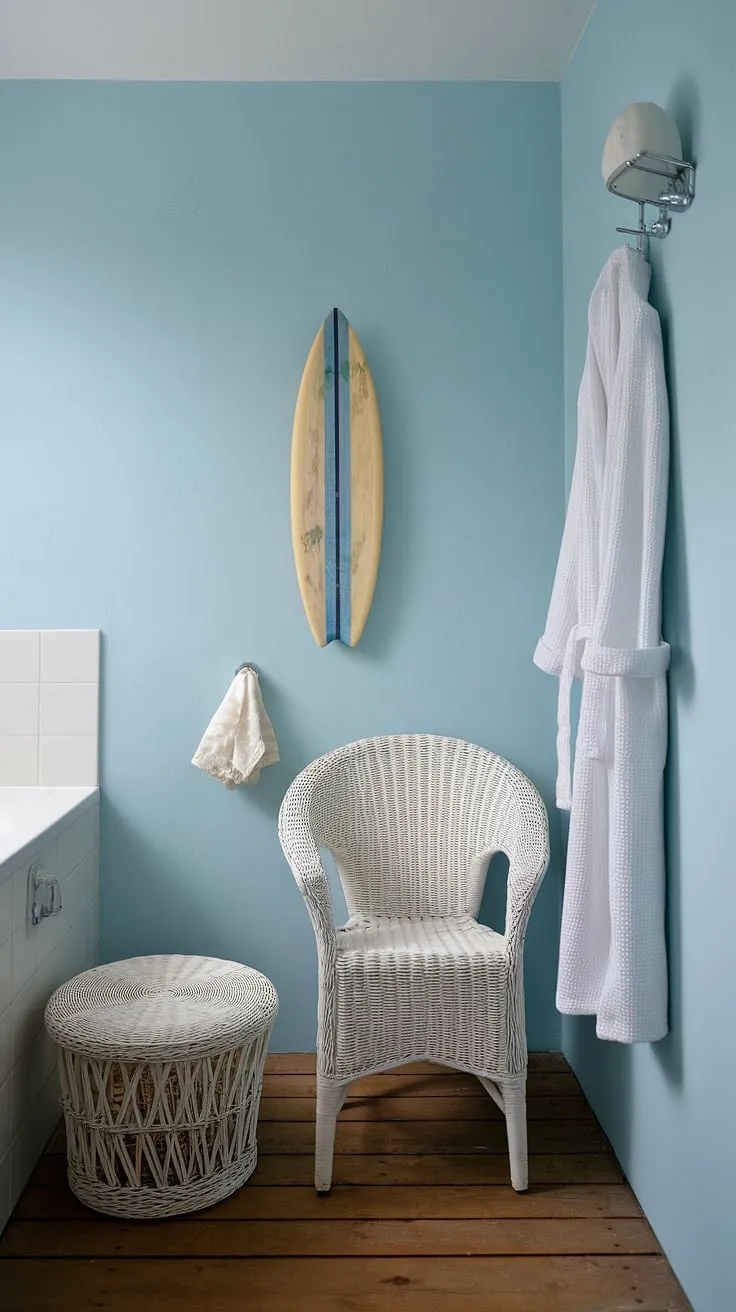 This beach cottage style bathroom embodies the perfect beach house bathroom aesthetic.  Blue beach bathroom ideas and white coastal bathroom ideas combine effortlessly to create a stunning coastal aesthetic bathroom, even within a small space.  The surf theme bathroom details add a playful touch to this serene coastal small bathroom, offering inspiring beach aesthetic bathroom ideas.
