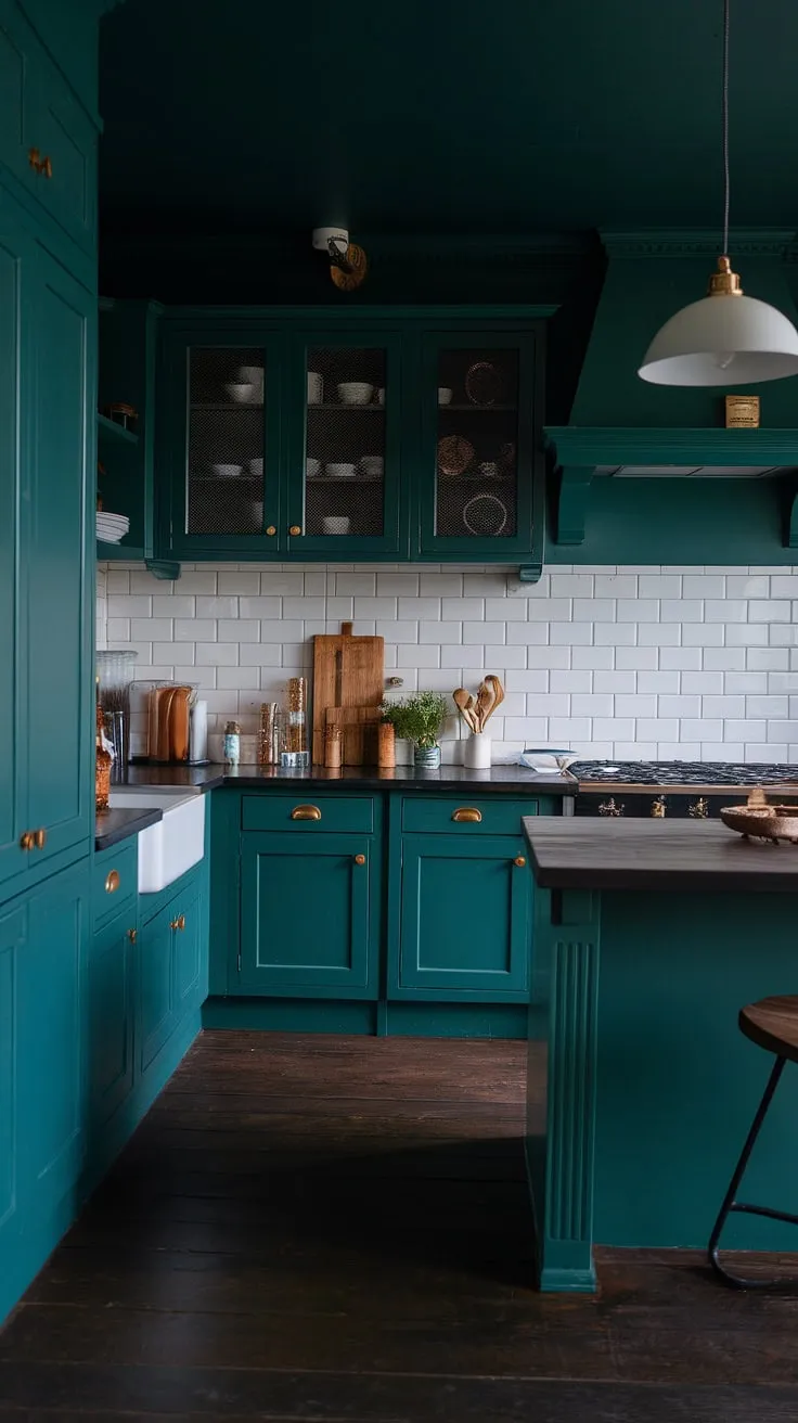 This dark green kitchen embodies a dark academia aesthetic with its moody decor, featuring rich green cabinets and a cozy ambiance perfect for a stylish dark home.