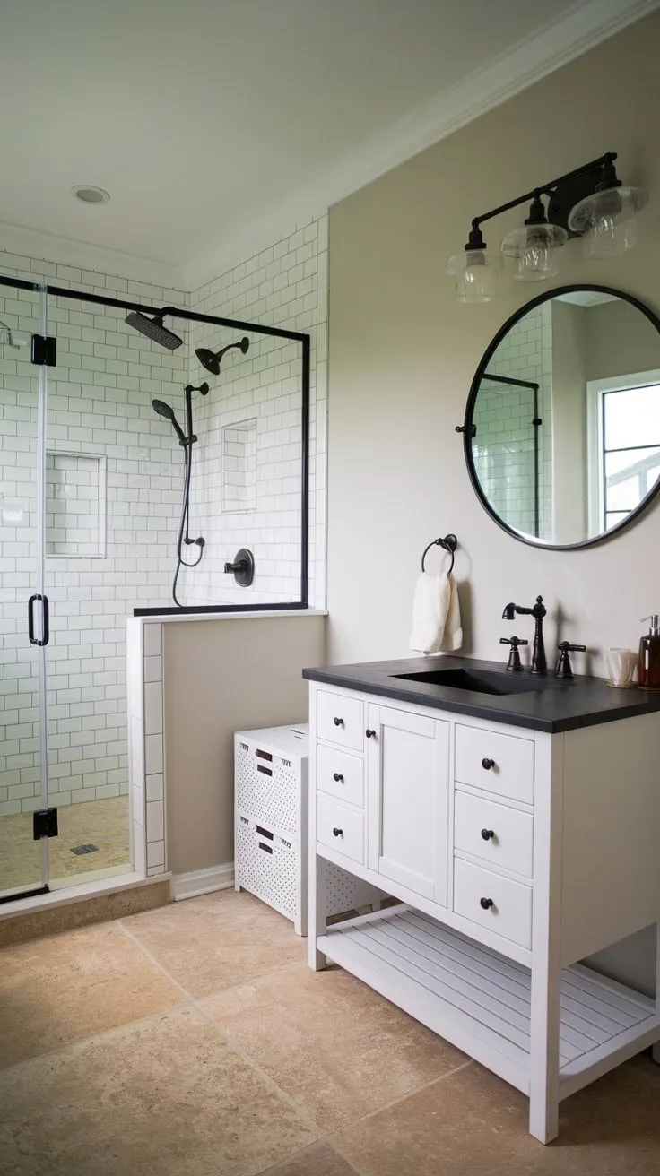 A modern farmhouse bathroom boasts a sleek white vanity, black sink, and multi-head shower, all complemented by light grey walls and beige tile flooring.