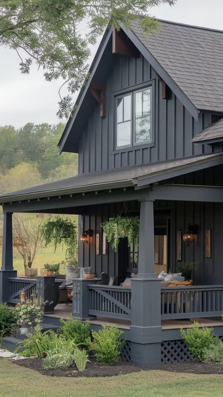 Nestled in lush greenery, this dark gray farmhouse harmoniously combines craftsman and modern styles, inviting you to unwind on its charming porch surrounded by nature's beauty.