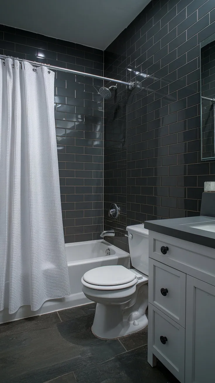 Dark bathrooms done right: This grey bathroom showcases how effective dark grey tile bathroom designs can be in small grey bathrooms. The clever use of light and grey bathroom tiles creates a luxurious feel, offering inspiration for your next bathroom design styles.