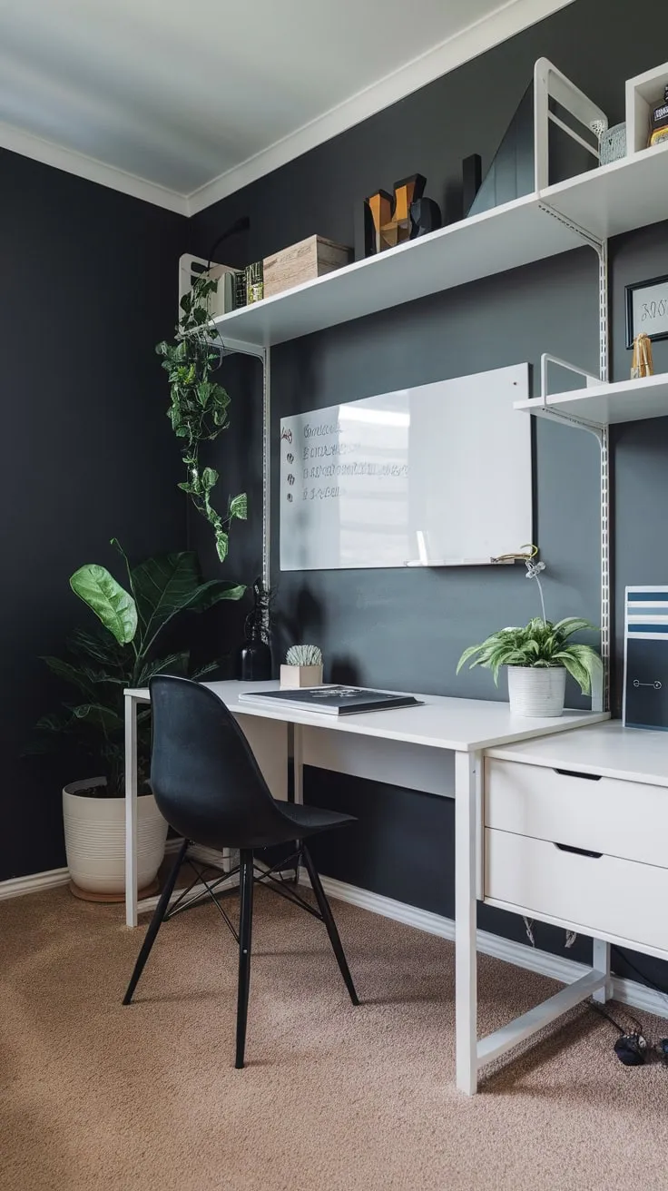 A sleek modern home office boasts a dark grey wall, white floating shelf and desk, black chair, and potted plant, all complemented by beige carpeting.
