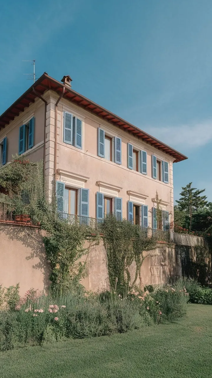 Nestled in Northern Italy, a sun-kissed stone villa with vibrant blue shutters and a lush garden offers a serene escape where breathtaking views invite you to savor every moment.