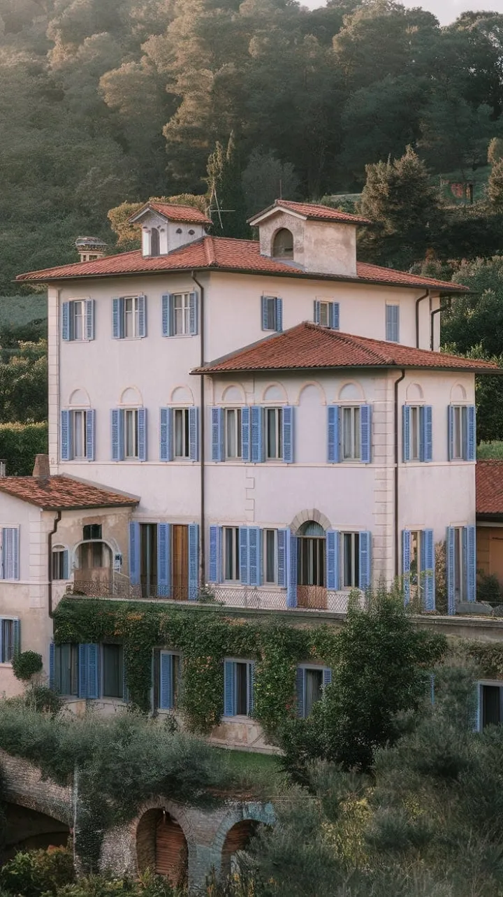 Nestled in the gentle glow of a Northern Italian summer, this villa embodies a dreamy escape with its vibrant red roof and blue shutters, offering a postcard-perfect slice of paradise.