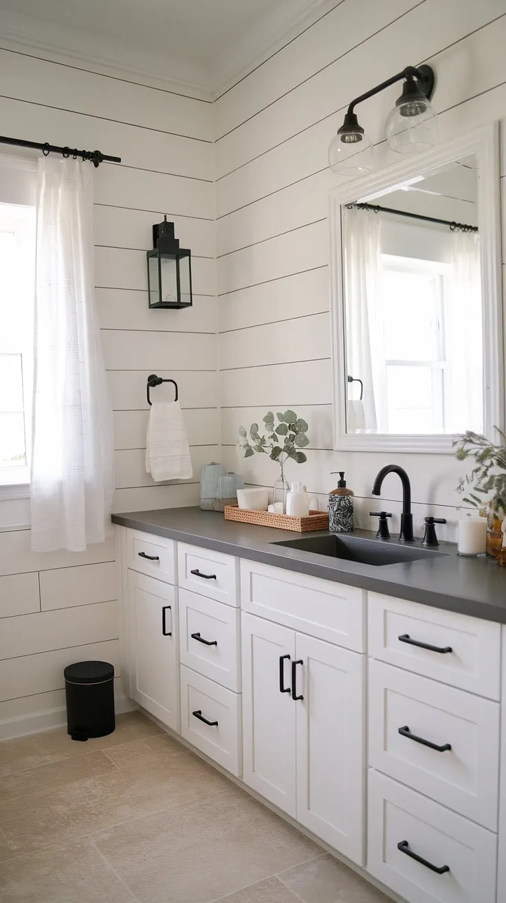 This modern farmhouse bathroom features white cabinets, a black sink and faucet, and shiplap walls, offering stylish master bathroom ideas for your bathroom remodel designs.