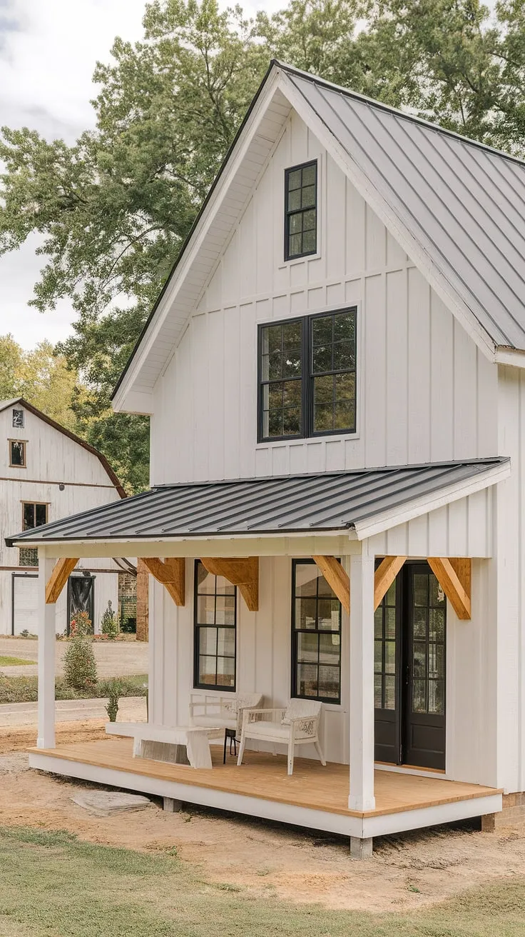 A modern farmhouse with a rustic white exterior features a small L-shape porch, black windows, and wood accents, creating a stunning house exterior aesthetic alongside a barn style farmhouse.