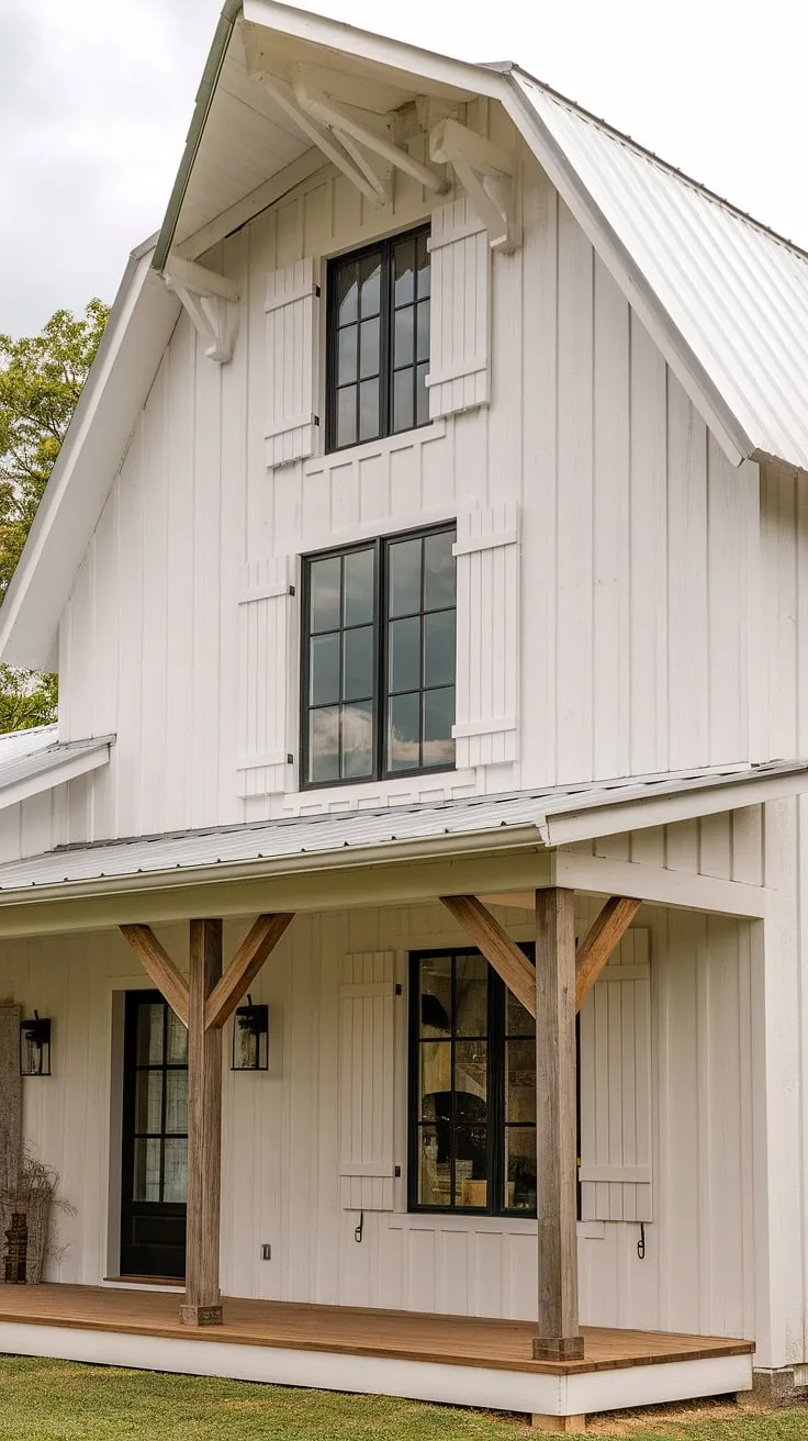 This charming white farmhouse with shutters and black windows, complemented by wood accents, highlights stunning small farmhouse exterior ideas and a cozy L-shaped porch in its remodel.