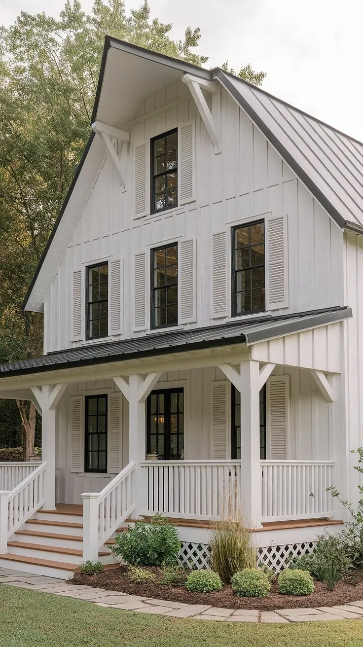 This modern farmhouse features a white rustic exterior with black windows and wood accents, showcasing an L-shaped porch and charming white shutters that enhance its cozy barn-style aesthetic.
