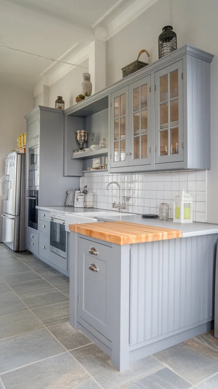 A sophisticated grey kitchen blends modern built-in cabinetry with cottage-style charm, all unified by grey countertops and flooring against crisp white walls.