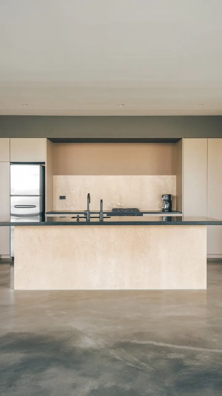 This modern kitchen blends calming beige and grey tones with sophisticated black accents, featuring a stylish island that serves as a hub for culinary creativity.