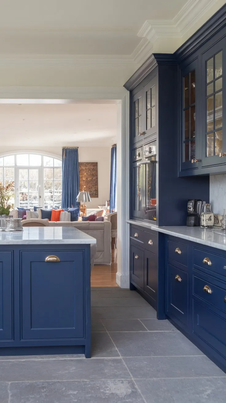Sleek navy blue cabinets and white marble countertops define this open-concept modern kitchen's sophisticated style