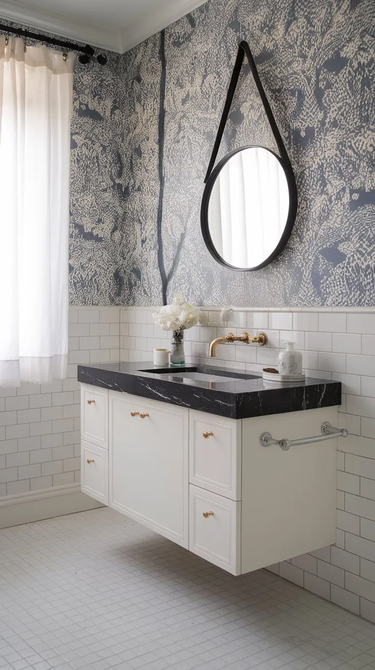 Serene sophistication meets modern minimalism in this powder room. The floating vanity with its black marble countertop and gold faucet is a stunning centerpiece, perfectly complemented by the blue and white floral wallpaper and crisp white tiles. A touch of elegance for even the smallest of spaces.
