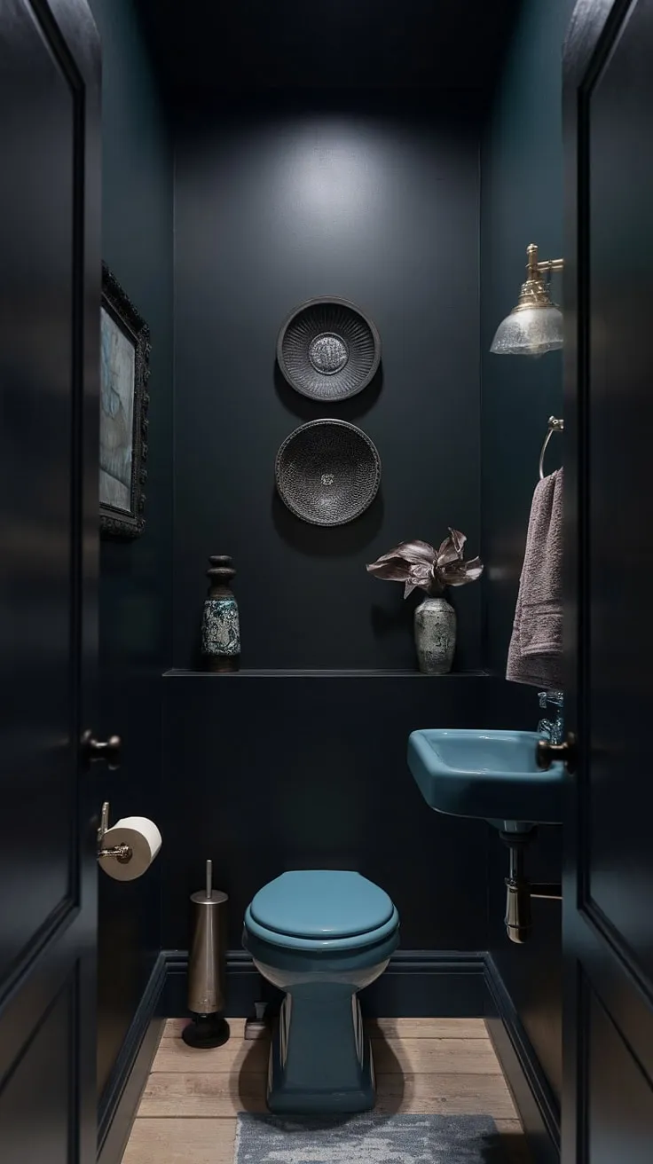 The dark tiny bathroom showcases a master bath remodel with a moody half bath aesthetic, enhanced by carefully chosen decorative items.