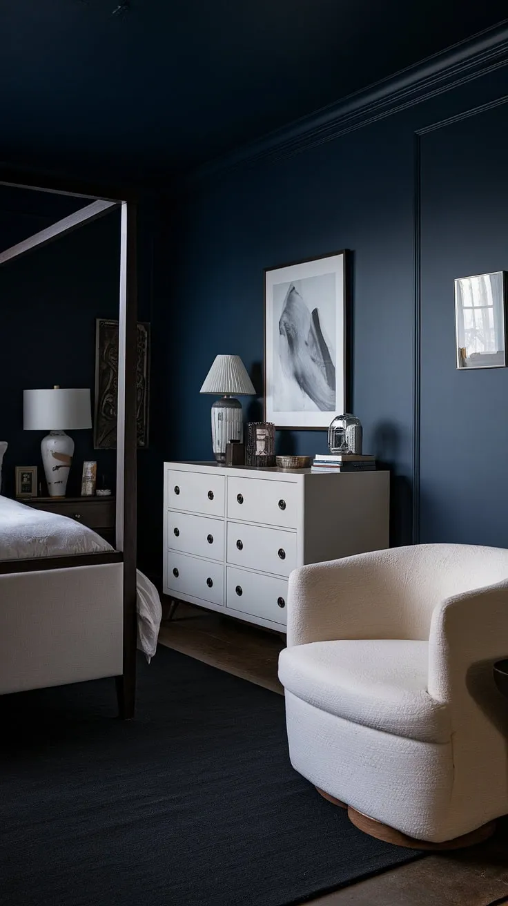 Transform your space with relaxing blue bedroom ideas featuring a moody blue palette, dark interior design, and a striking contrast of a white bed against dark walls for a modern dark hotel room aesthetic.