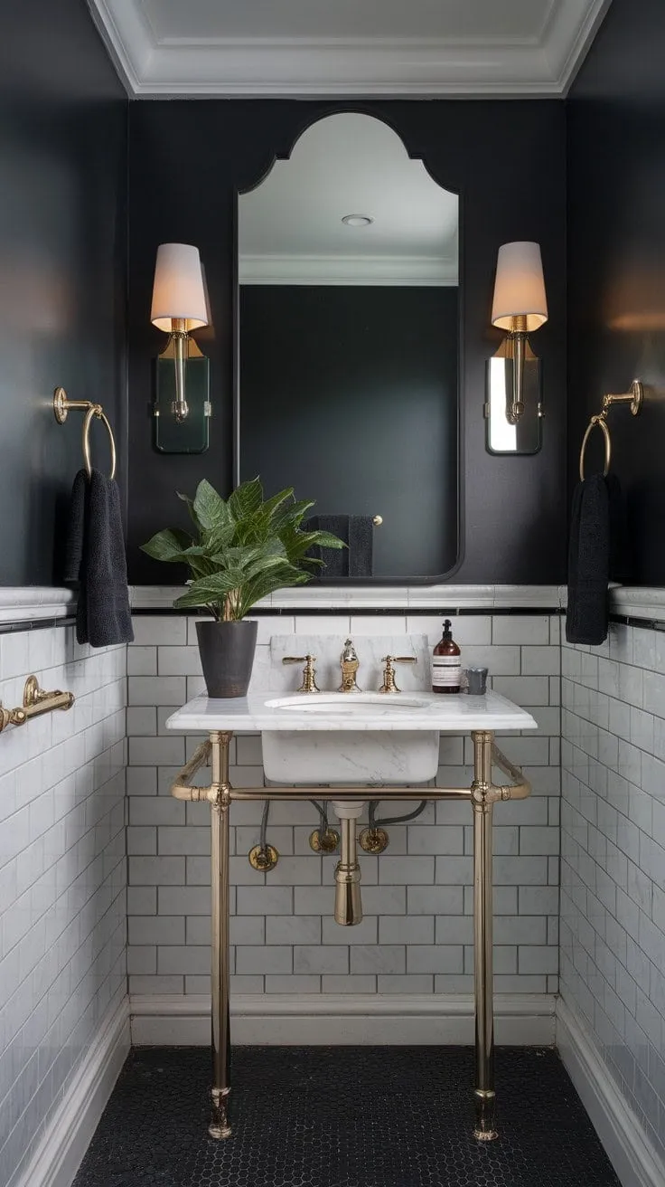 In this powder room, dark drama and opulent detail converge, where striking black, white, and grey hues are enlivened by gold accents and a hint of greenery, crafting a sanctuary of sophisticated elegance.