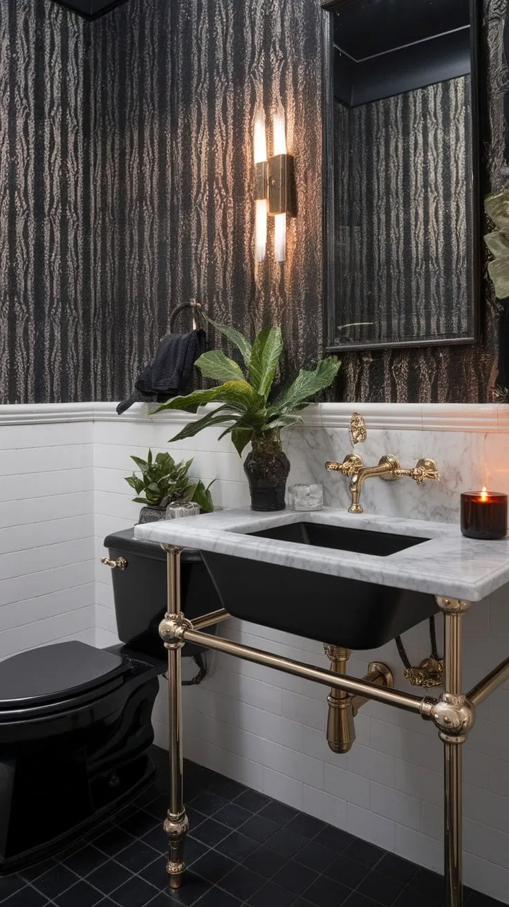 In this monochrome powder room, dark drama and refined luxury converge, where cool marble and rich wallpaper harmonize with golden fixtures and a soothing potted plant to create a captivating sanctuary of style.