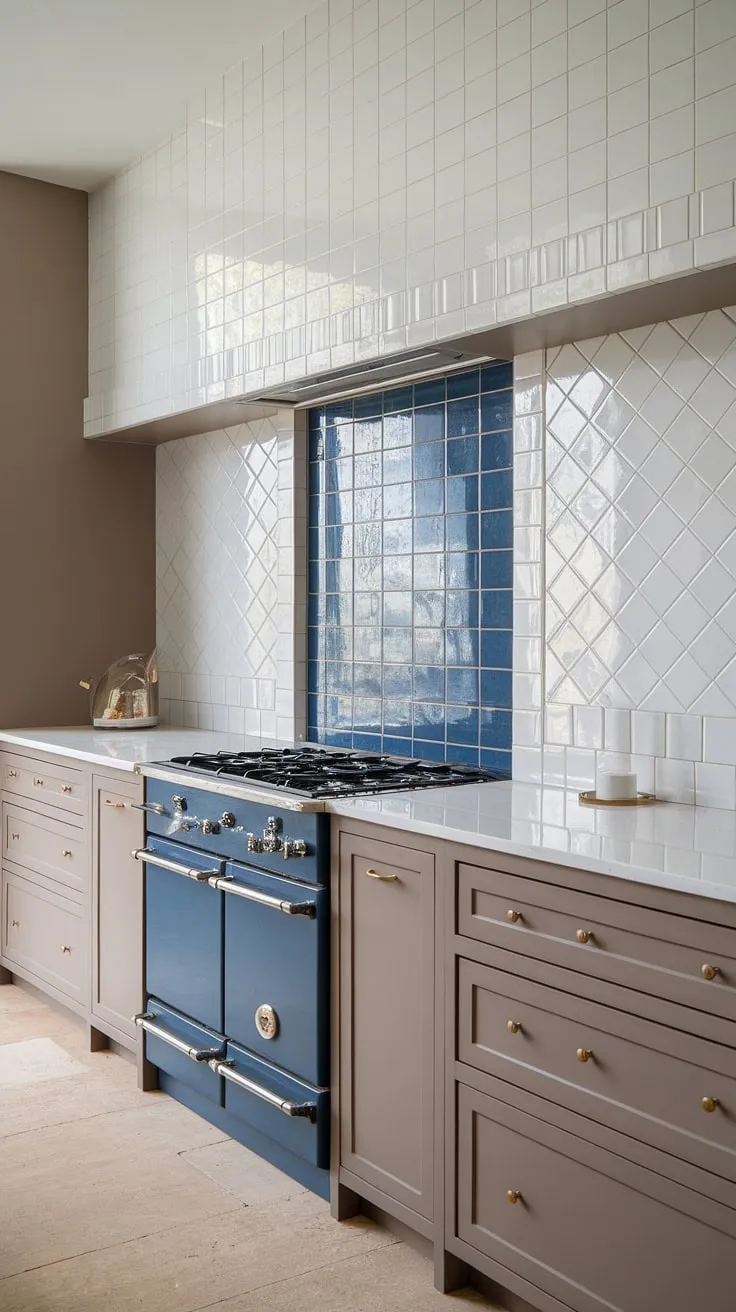 Sophisticated simplicity defines this modern neutral kitchen.  The taupe cabinet backsplash, paired with a glossy herringbone square tile backsplash in white, creates a calming backdrop.  A pop of blue on the simple stove backsplash adds a touch of unexpected vibrancy, while the textured tile backsplash and white kitchen tile backsplash maintain a clean, cohesive look. The neutral kitchen backsplash and pantry backsplash choices ensure a timeless design.