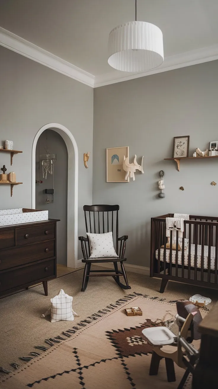 Dark wood and soft gray create a sophisticated sanctuary for the little one. This nursery effortlessly combines Scandinavian design with vintage accents, resulting in a space that is both stylish and incredibly comforting. A perfect blend of old-world charm and modern simplicity.