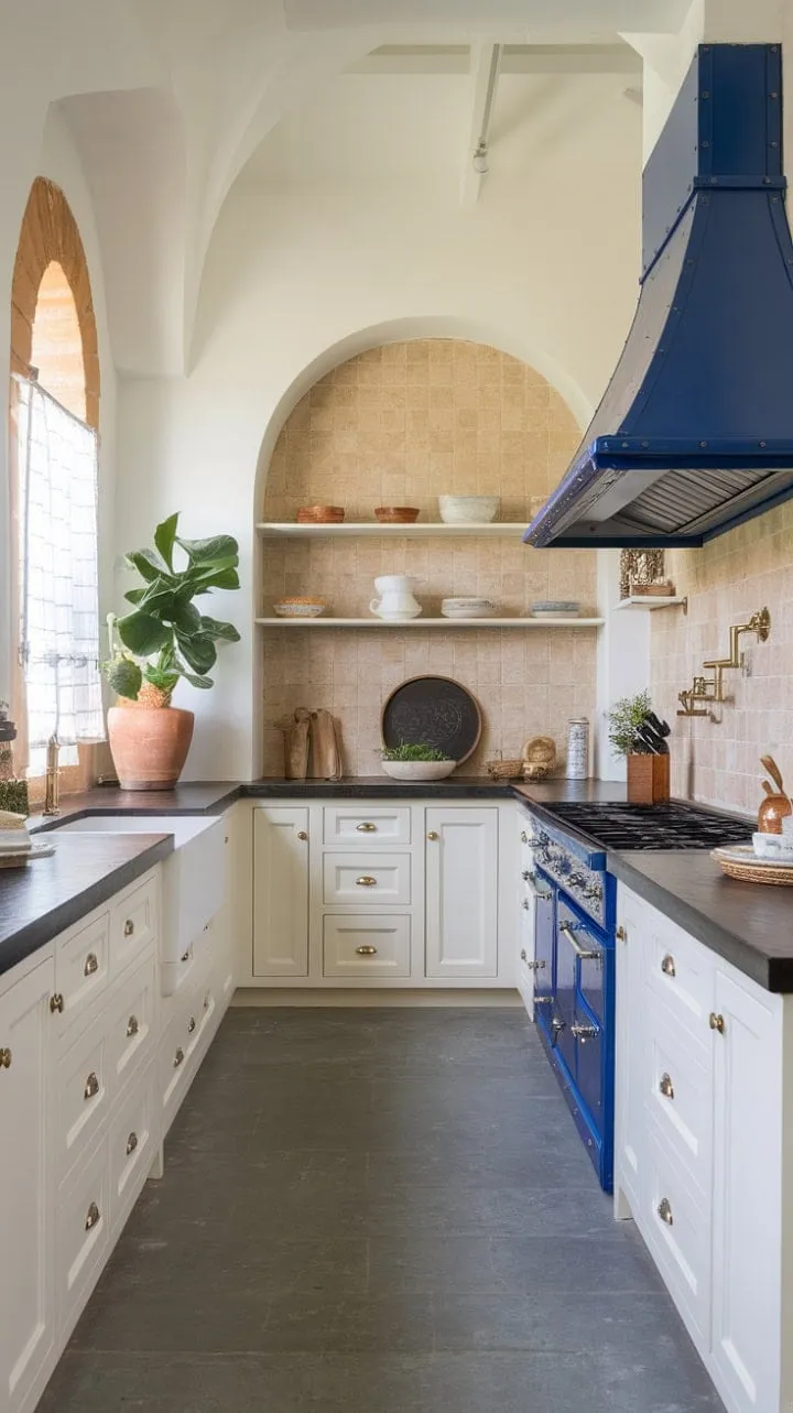 This Spanish-inspired kitchen exudes relaxed elegance with its crisp white cabinets, rich dark countertops, and a vibrant blue range hood that hints at culinary adventures.