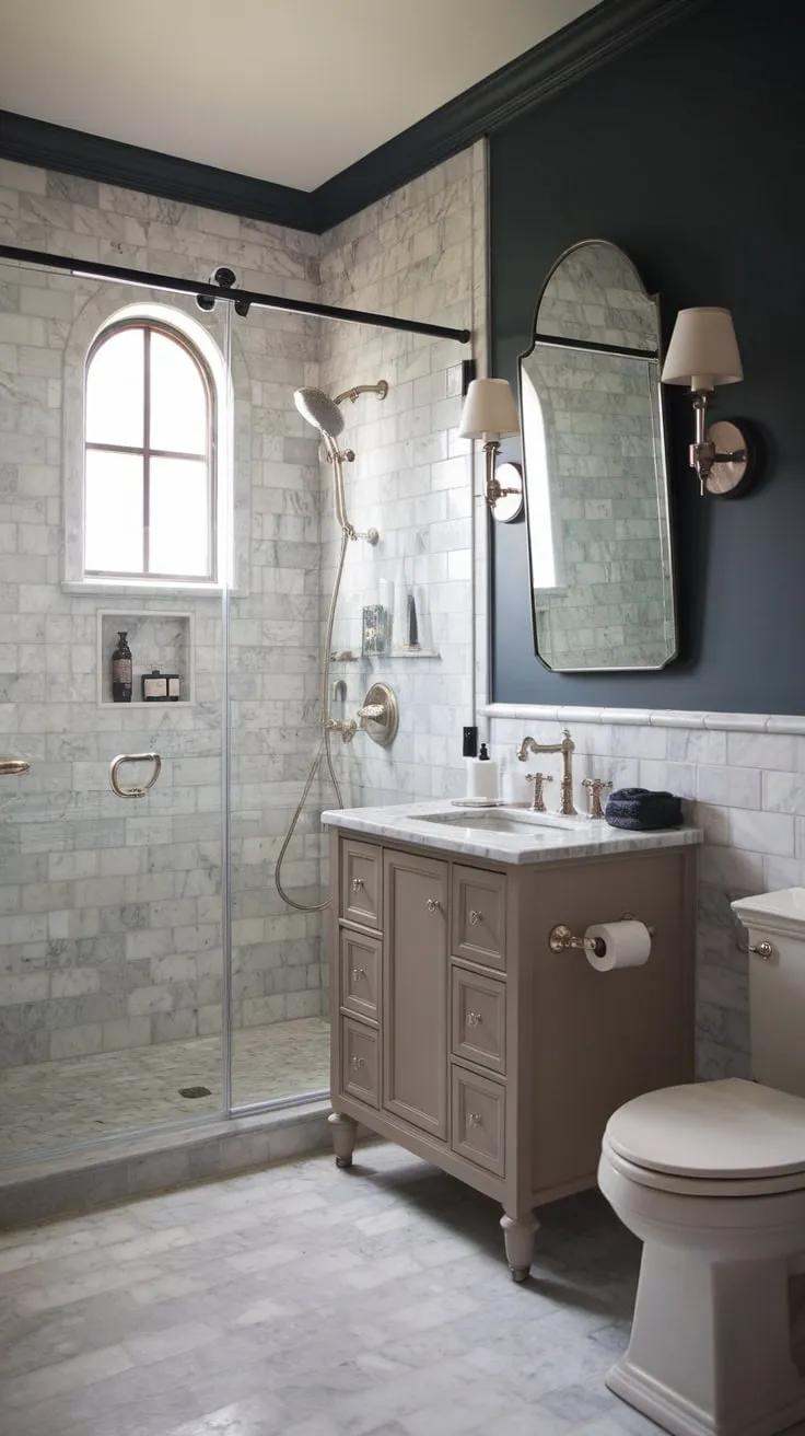 A moody marble master bathroom remodel blends vintage charm with modern wet-room functionality.